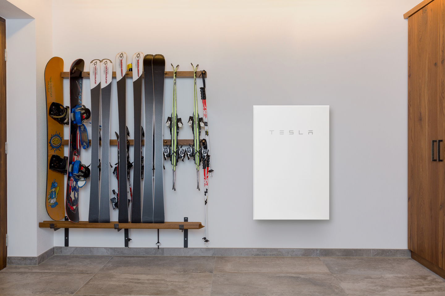 Powerwall 2 drinnen an einer Wand montiert neben Skiequipment